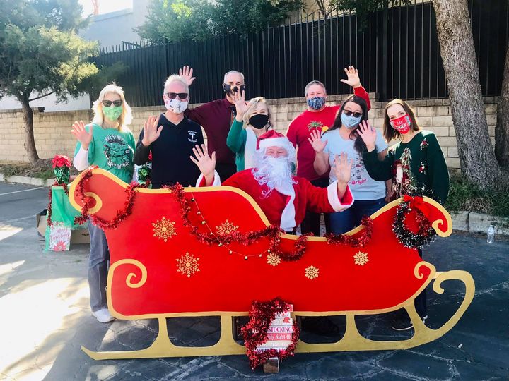 Santa in his sled with helpers, for children's covid drive through